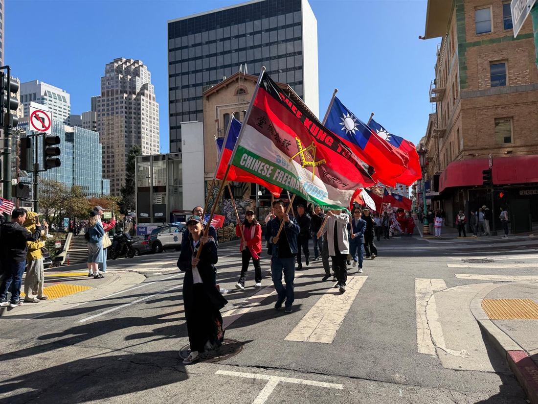 Flag bearers carrying the Chee Kung Tong banner and Republic of China flags through Chinatown
